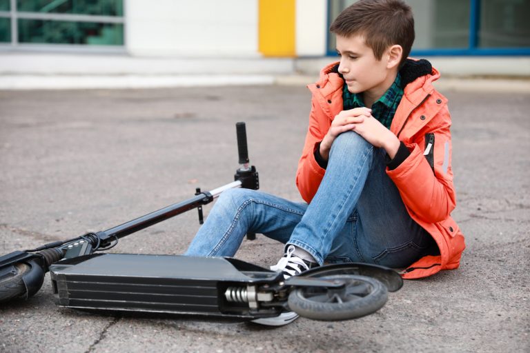 Teenage,Boy,Fallen,Off,His,Kick,Scooter,Outdoors
